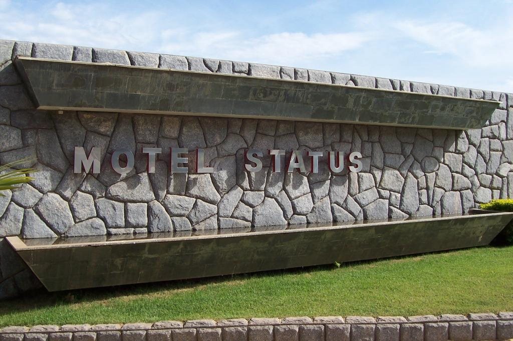 Letreiro do Motel Status na cascata de pedra da entrada