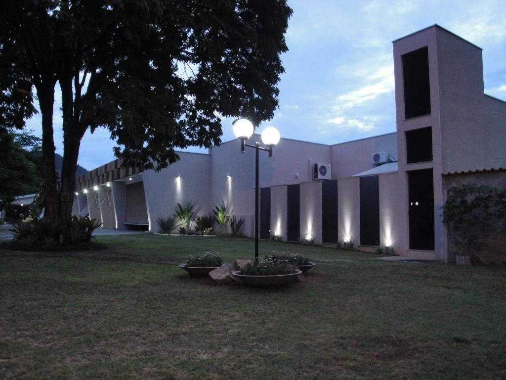 Blocos de suítes iluminados à noite, com jardim à frente