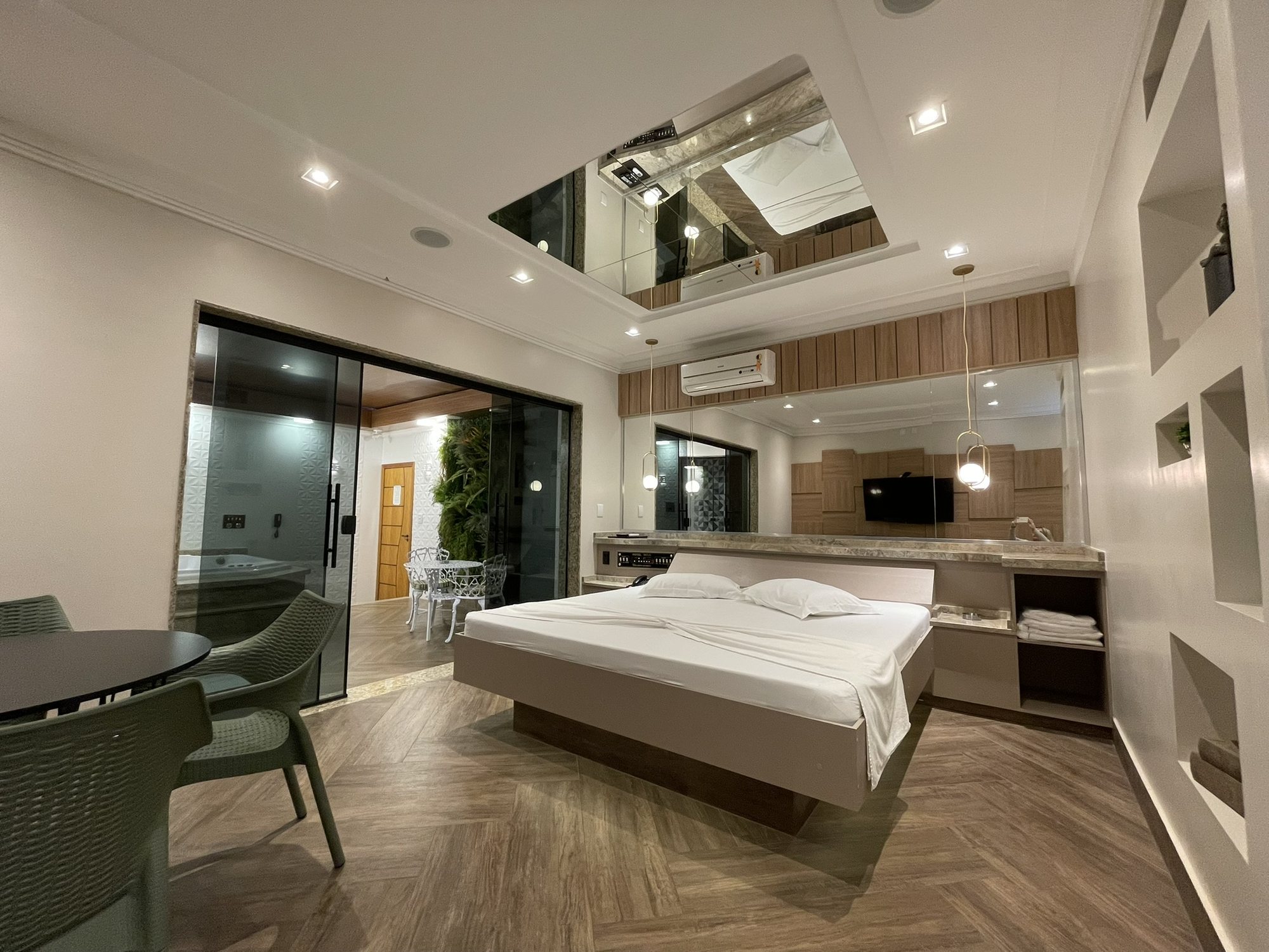 Quarto da Suíte SPA com cama de casal, mesa e espelho no teto